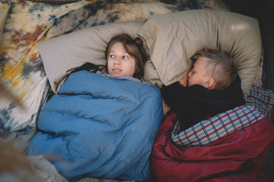 Two Friends Side by Side in Sleeping Bags. One looks scared.