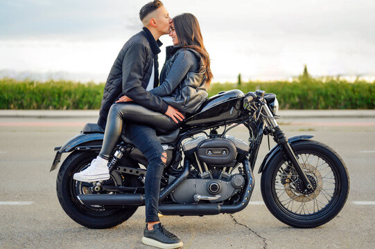 Man kissing his girl on the motorcycle