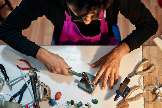 Overhead shot of Craftsman jeweler working the jewel on the work table