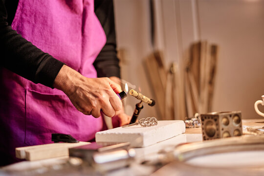 Jeweler craftsman lighting torch at work table
