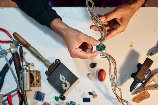 Overhead shot of Craftsman jeweler working the jewel on the work table