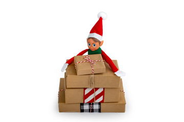 Christmas Elf  on a stack of gift boxes on an isolated  white background with copy space. Christmas...