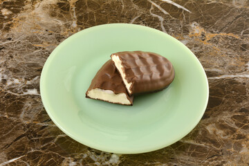 Chocolate marshmallow candy bar halves on green snack or dessert plate 
