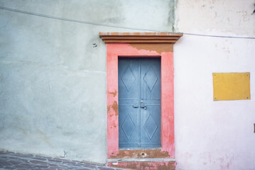 Pastel colored blue and pink door on a facade of an antique traditional colonial home in a colorful street in Oaxaca in Mexico