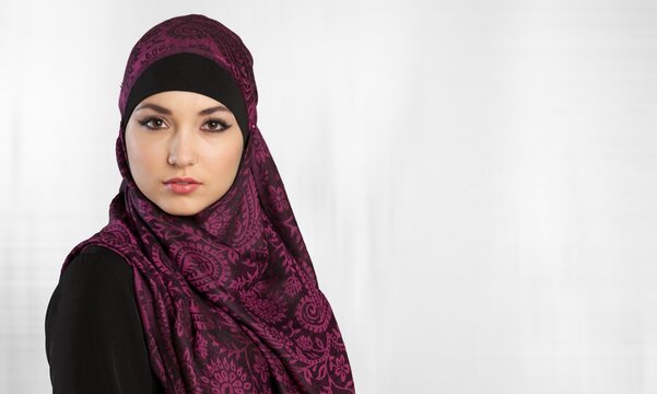 A Portrait Of Young Smiling Muslim Woman Wearing A Hijab Over Background Studio.