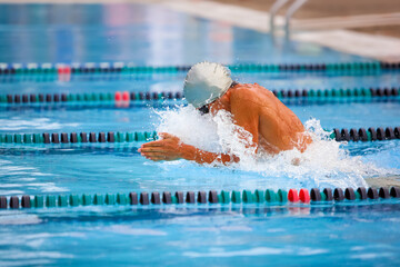 Breaststroke swimmer in a race - obrazy, fototapety, plakaty