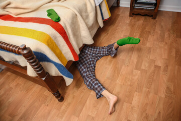 Young boy searching for his lost sock under the bed