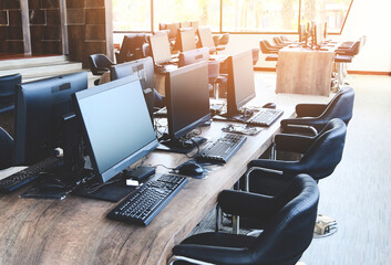 Group of computer with monitor neatly placed in a computer lab, computer room in the office modern with windows