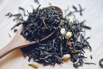Chinese dry tea on wooden spoon, jasmine tea dried for brew tea, leaf black tea