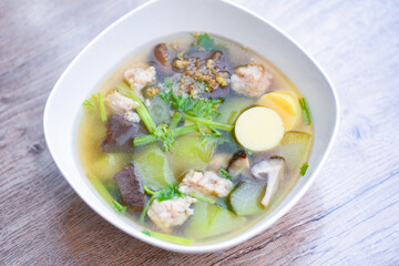 Tofu Soup bolw with winter melon vegetable eggs tofu slice meat ball and minced pork with celery, Clear soup blood pork thai healthy food asian on dark background, top view