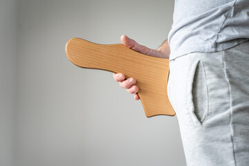 Side view of unknown person holding madero therapy wooden symbol of penis with erectile strength...