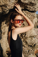 woman in black swimsuit sunglasses rocks posing summer luxury