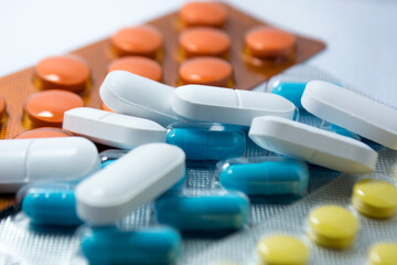 Medicine represented in pills, tablets and capsules (orange, blue, white and yellow)
