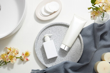 Top view of cosmetic jar in white bathroom with glassware and flower for cosmetic advertising , lifestyle content