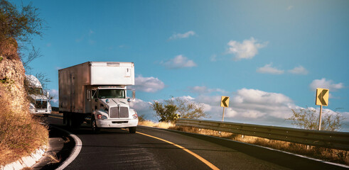 Cargo trailers on the highway at sunset transporting commercial cargo. Transportation theme. Road...