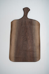 Handcrafted wooden walnut charcuterie serving board on a white background
