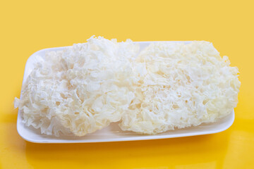Tremella Mushroom in white plate on yellow background.
