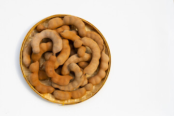 Tamarind tropical fruits in bamboo basket on white background.