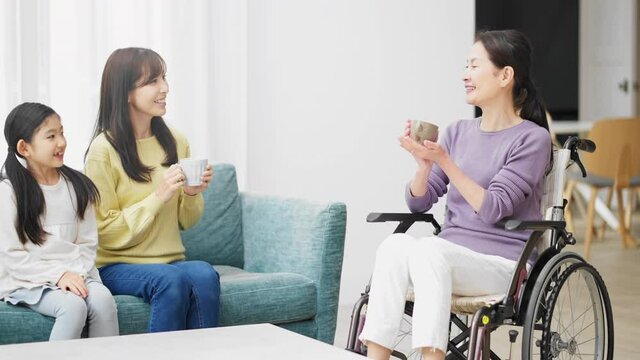 バリアフリーイメージ　車椅子のシニア女性と話す娘と孫
