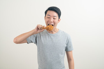 young Asian man with fried chicken on hand