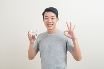 young Asian man with glass of water on hand