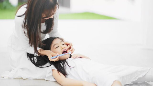 子供の仕上げ磨きをする母親