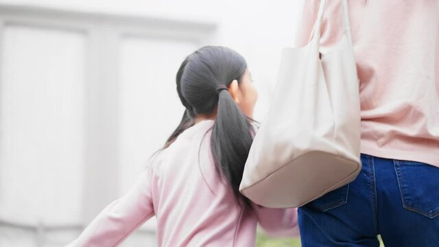 手をつないで歩く親子