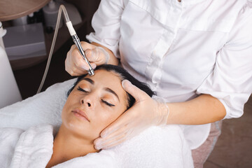 Obraz na płótnie Canvas Close-up portrait of a caucasian woman getting facial hydro microdermabrasion peeling treatment in a spa salon
