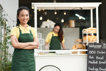 Portrait of happy young woman working as street food vendor