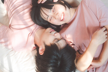 Happy young adult asian lover couple living together in bedroom at home.