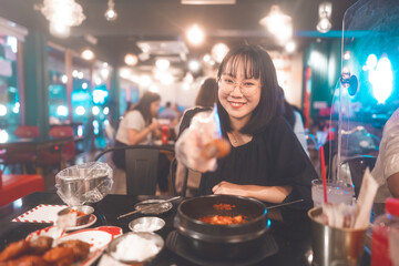 Portrait happy smile young adult asian woman holding fried chicken at Korean restaurant.