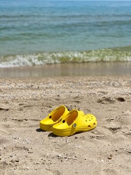 Bright yellow Rubber sandals or Crocs. Summer vacation trendy shoes. Stylish sandals. Yellow footwear.