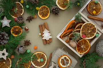 Zero waste Christmas concept. Natural materials wood, paper, fir branches, cones, nuts, dried citrus fruits, cinnamon. Flat layout frame. Eco-greeting card in muted natural shades. New Year 2022 gifts