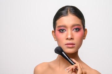 woman wearing pink makeup and holding a blush brush