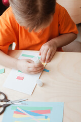 Little Girl Making Christmas Card sitting by table