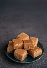 Plate of Butterscotch Fudge from Above on a Dark Background with Copy Space