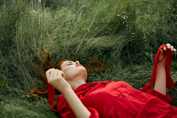 woman in red dress lying on the grass fresh air nature romance