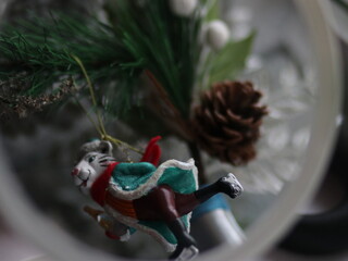 Christmas toy tiger with a bottle hanging on a spruce paw