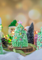 Butter cream cake decorate for Christmas festival with green butter cream and sweet candy, closeup.