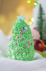 Butter cream cake decorate for Christmas festival with green butter cream and sweet candy, closeup.