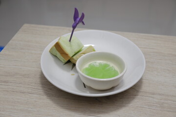 bread steamed custard in a white plate on a wooden table