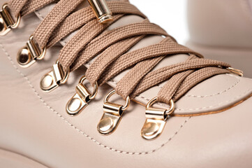 Womens beige leather boots with zip and lacing, photographed against a white background.