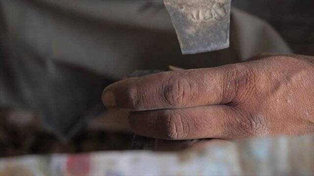 Slow motion video of a carpenter working on a house furniture design by shaping a piece of wood.