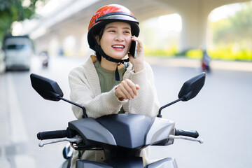 Asian woman driving a motorbike on her way to work