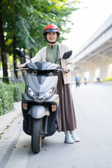 Asian woman driving a motorbike on her way to work