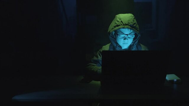 Young Boy Security Hacker Typing On A Laptop Computer At Night. - static