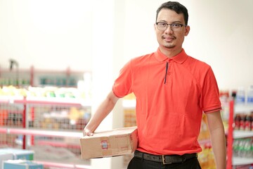 an employee of a supermarket wear uniform lifting inventory items