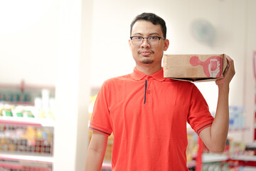 an employee of a supermarket wear uniform lifting inventory items