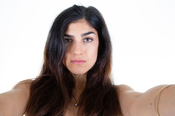 Young woman taking selfie with cell phone smartphone on white background