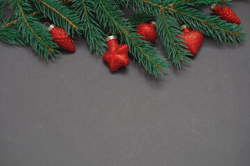 Fototapeta na wymiar Winter background with Christmas tree branches, cones, Christmas toys and Christmas cookies, with black space for replicas